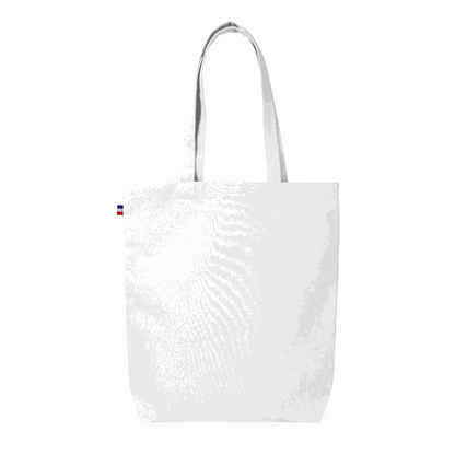 Sac cabas en coton beige avec soufflet de fond, fabriqué en France, posé sur une table en bois avec accessoires de mode

