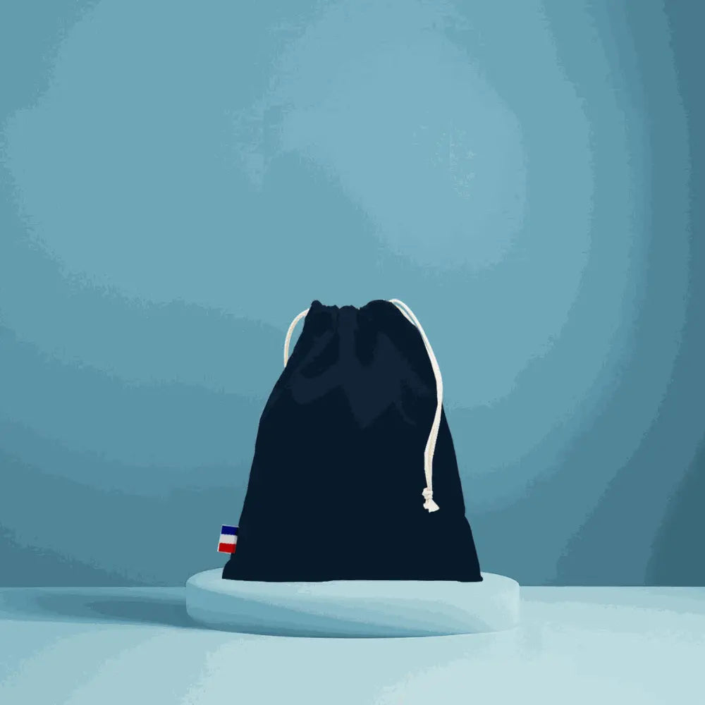 pochon en coton tissé noir avec cordon blanc, fabriqué en France, durable et élégant, sur fond bleu